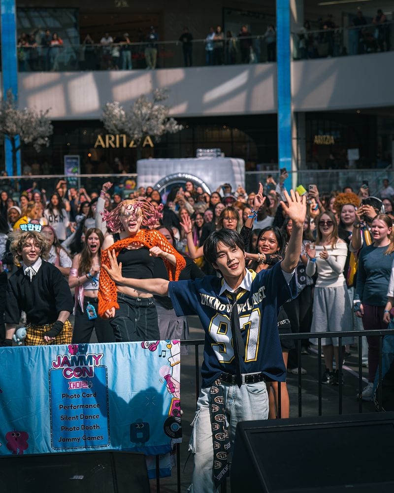 A JAMMY CON performer dancing with fans gathered around the stage.